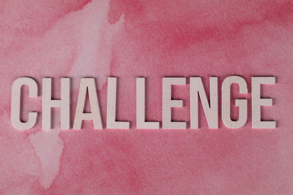 Text 'CHALLENGE' in bold on textured pink watercolor background for motivation.