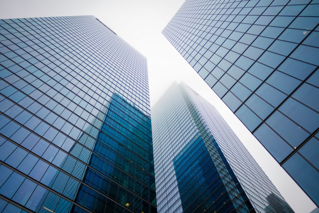 Looking up at sleek glass skyscrapers disappearing into the misty sky.